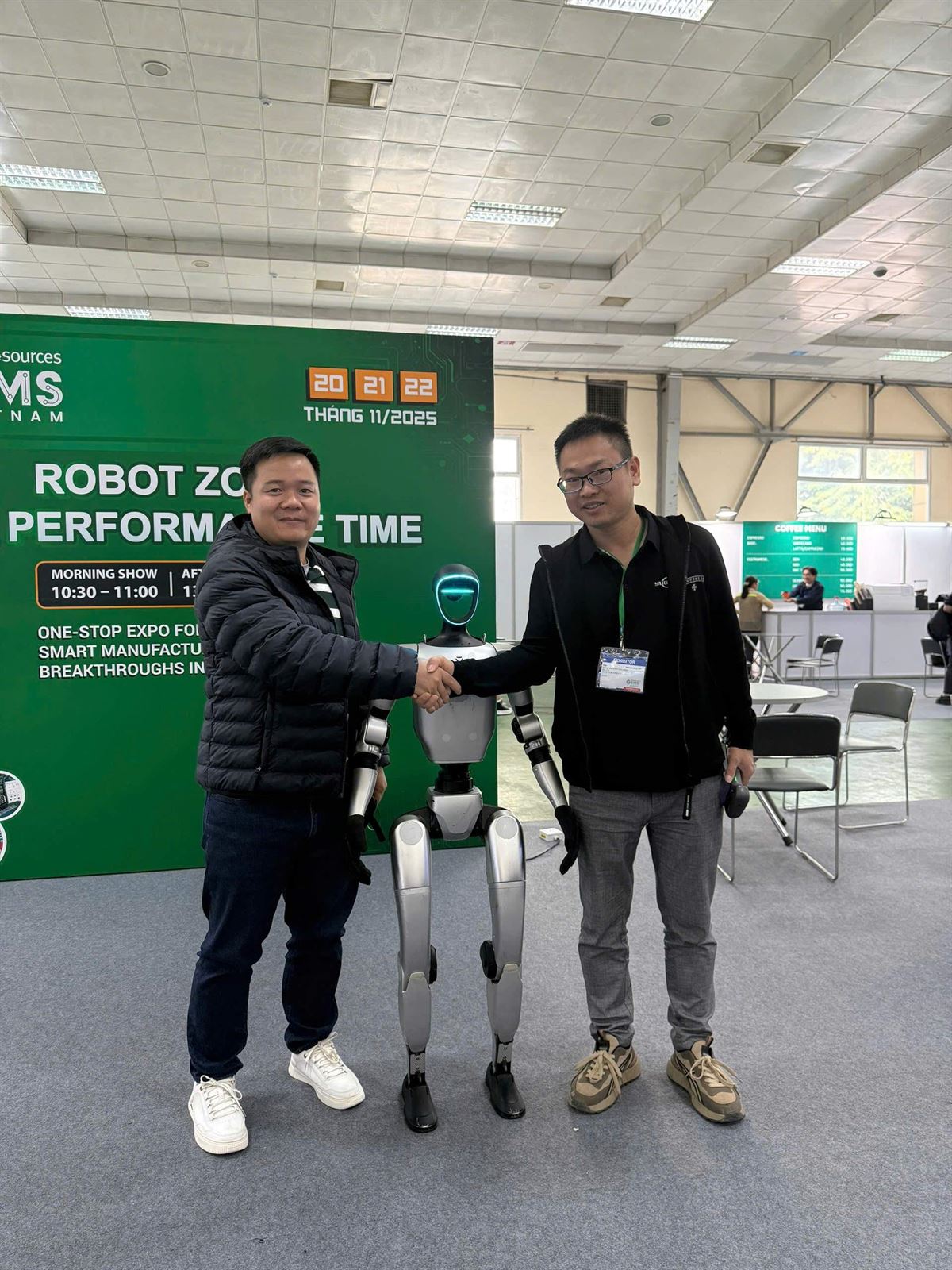 BAT Technology member shaking hands with a humanoid robot at GEIMS Vietnam 2025